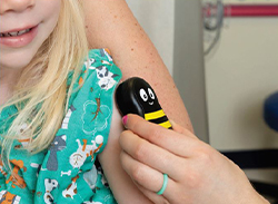 A Buzzy® bee being applied to a child's arm.