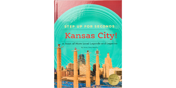Cover of the book &ldquo;Step Up for Seconds: Kansas City!&rdquo; showing an illustrated Kansas City skyline with a teal circular design.