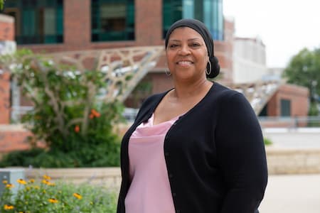 Female children's mercy employee smiling, standing outside of Adele Hall hospital.