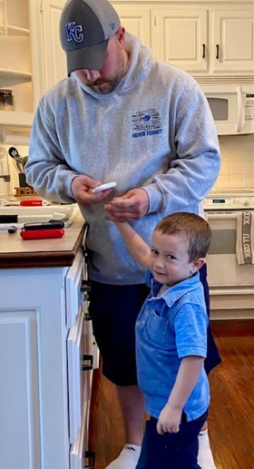 Ryan Koehler in his home kitchen testing his son's insulin level.