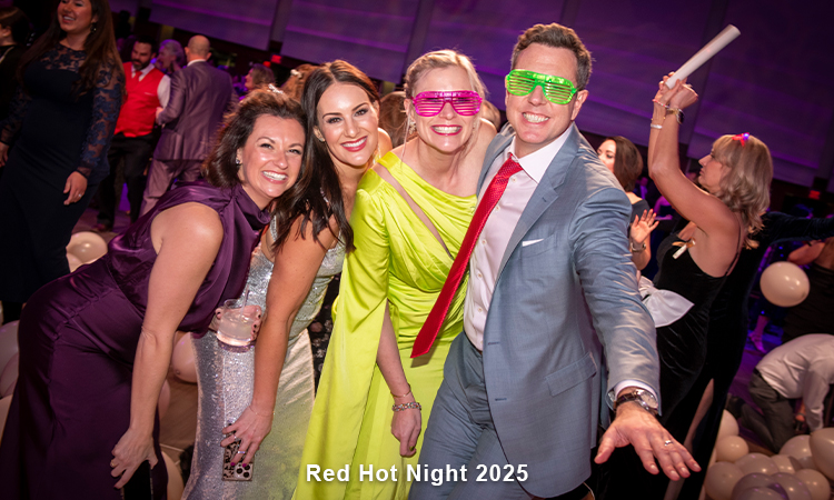 Four people in eveningwear are smiling at the camera. Two have on fun, neon-colored eyeglasses. WOrds read: Dream Big Day 2024.