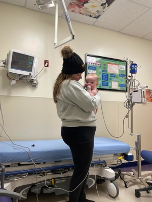 Mom carrying Auggie inside patient room