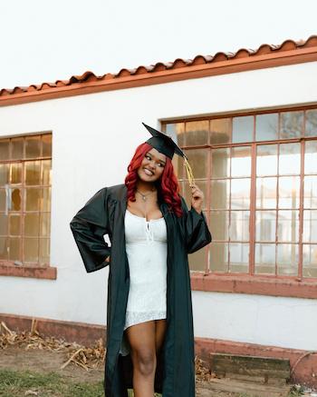 Lanayah wearing black cap and gown for graduation